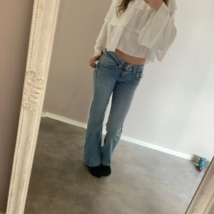 snygga blåa jeans - Säljer ett par ljusblå jeans från Gina Tricot med bootcut-passform och klassiska fem fickor. Jeansen har låg midja och stängs med dragkedja och 2 knapp. Perfekta för dig som gillar en retroinspirerad look. Har haft dem i 1 år och dem har blivit för små för mig.
