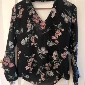 Blommig blus med öppen rygg - Blommig blus med öppen rygg från GinaTricot i storlek 36. Superskön att ha på sommaren då den är väldigt sval! 🌸