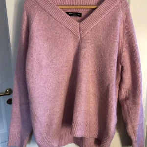 Rosa stickad tröja med v-ringning - Mysig rosa stickad tröja från FB Sister med v-ringad halsringning och bred ribbad kant. Tröjan har lång ärm och är i en mjuk, skön kvalitet. Tröjan är i storlek xs men skulle säga att den snarare passar som en s 🩷
