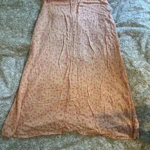 Långkjol med blommigt mönster från Pull&Bear - Säljer denna jättefina orangea långkjol från Pull&Bear med rosa blommigt mönster!! Kjolen har en smal passform och dragkedja i sidan. Sprucken söm på insidan, syns dock inte vid användning och kan lätt lagas med nål och tråd💕storlek l, men skulle snarare säga att den sitter mer som en m. Hör av dig vid frågor eller om du har prisförslag!!💕