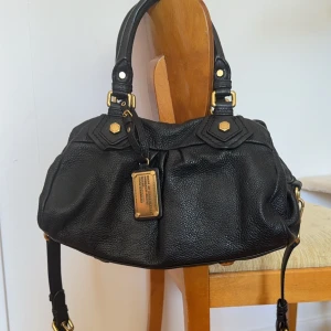 Marc Jacobs väska  - Så snygg marc jacobs väska ifrån classic q kollektionen. VÄDLIGT fint skick, inte använd mycket alls. Kommer med dustbag och avtagbart axelband. Måtten är ca 33x20x15cm. 