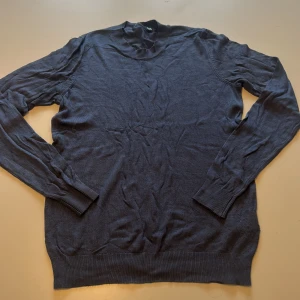 Mörkblå tröja från Lager157 - En enkel och stilren mörkblå tröja från Lager157. Tröjan har rund halsringning, långa ärmar och ribbade muddar vid ärmslut och nederkant. Perfekt för lager-på-lager och passar till många olika outfits.