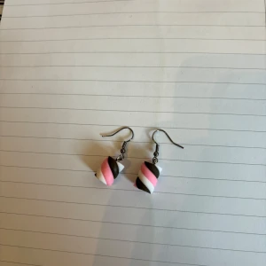 Handgjorda örhängen med randigt mönster - Unika örhängen med handgjorda pärlor i randigt mönster i rosa, vitt och brunt. Perfekta för dig som vill ha något färgglatt och lekfullt i din stil. Krokar i metall.