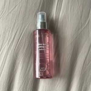 Hickap Setting Spray - Glow Monkey Setting Spray från Hickap i en rosa plastflaska med silvrig spraypump. Ger en strålande finish och håller sminket på plats hela dagen. Passar alla hudtyper och är 100% vegansk.