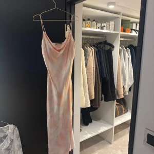Ljusrosa långklänning  - Säljer en ljusrosa långklänning med vita toner. Klänningen är i bra skick, endast använd en gång. Jättefin till sommaren!
