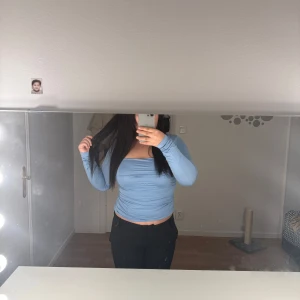 Ljusblå långärmad topp - Säljer en ljusblå långärmad topp med en smickrande passform som är helt oanvänd. Toppen har en stilren design med rynkade detaljer som ger en fin struktur. Perfekt för att lyfta din vardagslook eller för en kväll ute. Passar bra till både jeans och kjol, även kostymbyxor. PERFEKT nu till sommaren.