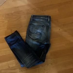 Blå jeans från Jack & Jones - Snygga blå jeans från Jack & Jones med en klassisk femficksdesign. De har en lätt tvättad look och är perfekta för en avslappnad stil. Märkeslappen på baksidan ger en extra touch av stil.