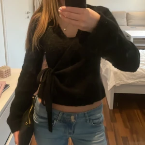 Svart knitted wrap cardigan från Gina Tricot - Säljer en svart tröja från Gina Tricot i storlek S. Tröjan har långa ärmar och en knytning i sidan som ger en snygg passform. Perfekt för en stilren look. Nypris är 399kr och jag säljer den för 149kr, pris kan diskuteras. Knappt använd.