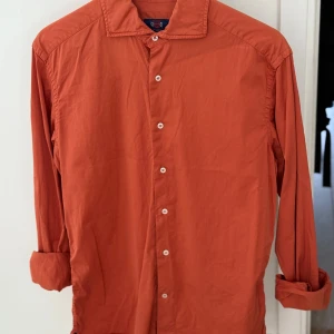 Orange skjorta från La Chemise - Snygg orange skjorta från La Chemise i slim fit. Skjortan har långa ärmar och knappar framtill. Perfekt för en stilren look.