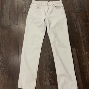 Vita jeansbyxor - Snygga vita jeansbyxor med klassisk design. De har en rak passform och är perfekta för en stilren look. Byxorna har en knapp och dragkedja framtill.