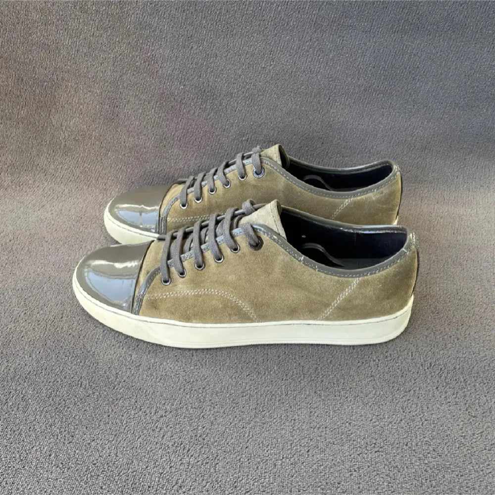 Snygga sneakers i en kombination av beige mocka och grå lackdetaljer. Skorna har en vit sula och grå snörning som ger en stilren look. Perfekta för en casual stil med en touch av elegans. Bara skorna ingår . Kengät.