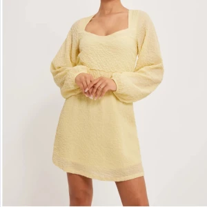 Nelly Ljusgul klänning Strl: 40, långa ärmar - Säljer en söt ljusgul klänning med långa ärmar och en fin struktur i tyget. Klänningen har en smickrande passform och en v-ringad halslinje. Använd en gång så lapparna är nu bortklippta. Perfekt för vår och sommar! Nypris 499kr - https://nelly.com/se/produkt/nelly-all-for-me-dress_238453-0069/ 