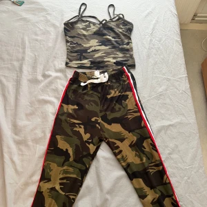 Set Camouflagefärgad linnetopp och byxor - Snygg camouflagefärgad linnetopp med smala axelband och v-ringning. Perfekt för en avslappnad och trendig look.