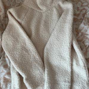 Mysig beige tröja från Lindex i fleece med en fluffig textur. Perfekt för kyliga dagar med sin bekväma passform och långa ärmar. Tröjan har en hög krage som ger extra värme och stil. Den är i storlek xs men passar också större storlekar då den är väldigt over sized! 💞