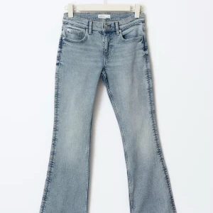 Ljusblå bootcut jeans  - Säljer ett par ljusblå bootcut jeans från Perfect Jeans, Gina Tricot. De har en klassisk femficksdesign och en knappgylf, samt lågmidjade. Perfekta för en avslappnad stil med en modern twist. Oanvända. 