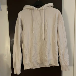 Beige hoodie från Weard - Säljer en stilren beige hoodie från Weard. Den har en klassisk design med dragsko i huvan och ribbade muddar vid ärmslut och nederkant. Perfekt för en avslappnad look.