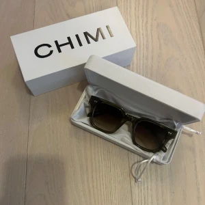 Gröna solglasögon från CHIMI - Snygga gröna solglasögon från CHIMI i modellen 04 och färg Green. De har en stilren design med transparenta gröna bågar och mörka linser. Perfekta för att ge en cool touch till din stil. Knappt använda, inga märken eller tecken på användning!💕💕orginalförpackning, putsduk, fodral och fodral i tyg följer med!