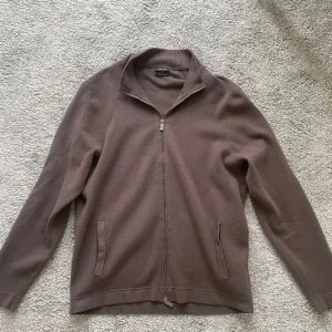 Massimo Dutti zip - Snygg brun tröja från Massimo Dutti med dragkedja framtill. Tröjan har en klassisk krage och två fickor. Perfekt för en stilren look.