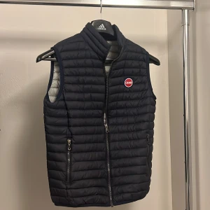 Svart dunväst från Colmar - Snygg svart dunväst från Colmar med dragkedja och två praktiska fickor framtill. Västen har en quiltad design och en liten logotyp på bröstet. Perfekt för kyligare dagar.