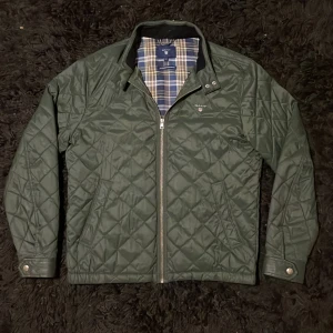 GANT vintage jacka - Säljer en snygg grön quiltad jacka från GANT. Jackan har en dragkedja framtill och en klassisk krage. Insidan är fodrad med ett stilrent rutigt mönster. Perfekt nu till våren och sommaren. Fits M. Hör av dig om du har några funderingar.