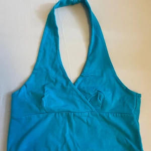 Turkos halterneck topp - Snygg turkos halterneck topp med omlott-design. 