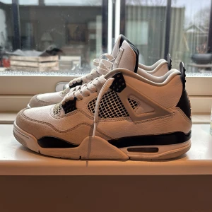Nike Air Jordans 4 military black - Snygga ÄKTA Nike Air Jordans i en stilren vit och svart färgkombination. Skorna har klassisk snörning och ikonisk Jumpman-logga på tungan och hälen. Perfekta för både streetwear och samlare. Creesskydd inkluderas. Köpt för 2 år sedan men ändast använts ett tiotal gånger. Perfekt skick. Originella skolådan är inkluderad.