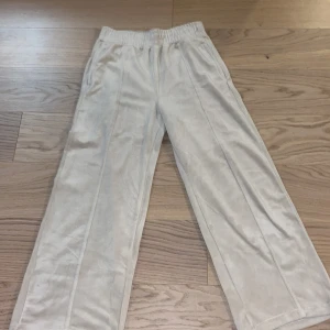 Beige byxor från Lindex Kids - Säljer ett par bekväma beige byxor från Lindex Kids. Byxorna har en elastisk midja och raka ben, vilket ger en avslappnad passform. Perfekta för vardagsbruk och gjorda i ett mjukt material.