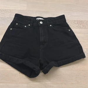 Svarta jeansshorts från g perfect jeans - Snygga svarta jeansshorts från g perfect jeans med hög midja och klassisk femficksdesign. De har en knapp och dragkedja framtill samt uppvikta benslut för en trendig look. Priset går att diskuteras. 
