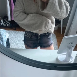 Jeansshorts med nitar från Bik Bok - Snygga jeansshorts från Bik Bok i en mörkblå tvätt. De har fransiga kanter och coola nitar på ena fickan. Perfekta för en edgy look i sommar. Passar bra till en avslappnad stil med en t-shirt eller linne. Längd 20,tvärs över 32