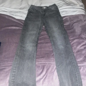 Lågmidjade Grå jeans från Gina Tricot - Snygga grå jeans från Gina Tricot med en klassisk femficksdesign. De har en rak passform och är perfekta för en avslappnad stil. Jeansen har en knapp och dragkedja framtill. Storlek 164 men passar som XS. Priset kan diskuteras.