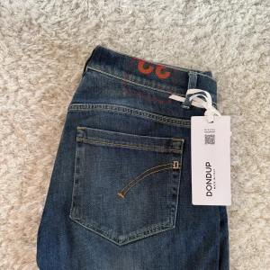 Blå jeans från Dondup - Hej! Säljer dessa snygga blå Dondup jeans med klassisk femficksdesign och knappgylf. Tillverkade i Italien. Storlek: 32 | Skick: 9/10 | Modell: George | Kontakta vid minsta lilla fundering! Mvh ResellGarms