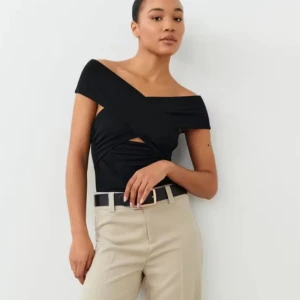 Svart offshoulder topp - Snygg svart offshoulder topp med unik design och asymmetrisk skärning. Perfekt för en trendig look.
