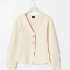 Ginatricot - Button cardigan  - Snygg beige kofta från Ginatricot med v-ringning och dekorativa guldknappar. Perfekt för en stilren look. Långärmad och i ett mjukt material som ger en bekväm passform. Har dock inte använt den mer än 1 gång! Det sitter lite tajt via medjan!
