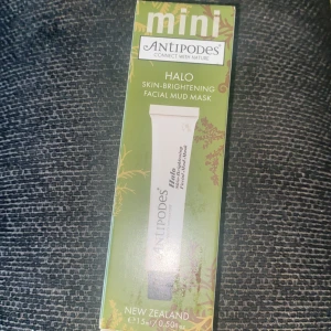 Antipodes Halo Skin-Brightening Facial Mud Mask - Mini Antipodes Halo Skin-Brightening Facial Mud Mask från Nya Zeeland. Denna ansiktsmask är designad för att ge huden en ljusare och fräschare look. Förpackningen är grön med naturinspirerat mönster och innehåller 15 ml.