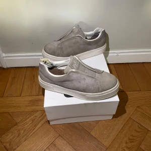 Grå sneakers från Eytys - Säljer ett par stilrena grå sneakers från Eytys i modellen Doja S-O. Skick 6/10 men om du har ett mocka kit kan ni lätt få upp dom till 7-8/10! Slitningar i hälen som ni inte känner av eller ser när ni har på er skorna. Storlek 40 men passar även 39 och 41