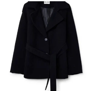 Svart kappa från NA-KD - Elegant svart kappa från NA-KD med knappar och ett matchande bälte i midjan. Perfekt för en stilren look. Kappan har en klassisk krage och långa ärmar.