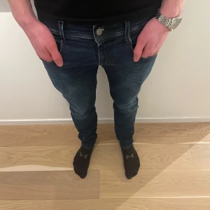 Mörkblå jeansbyxor - Snygga mörkblå jeans med en klassisk femficksdesign och knappgylf. Perfekta för en avslappnad stil. Passformen är slim och de har en midwaist skärning. De är ifrån replay och passar till allt. Skriv vid funderingar!