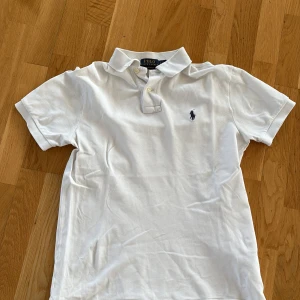 Vit kortärmad pikétröja från Ralph Lauren - Säljer en klassisk vit pikétröja från Ralph Lauren. Använd ca 3 månader.