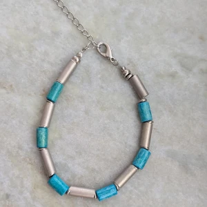 Turkost och silverfärgat armband - Snyggt armband med turkosa och silverfärgade pärlor. Armbandet har en justerbar kedja och karbinhake för enkel användning. Perfekt för att ge en färgklick till din outfit.