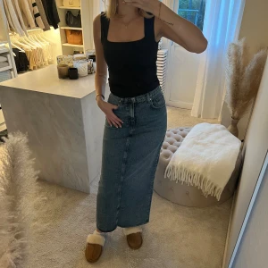 Lång jeanskjol från H&M - Snygg lång jeanskjol i blå denim med klassisk femficksdesign. Kjolen har en slits baktill för extra rörelsefrihet och stängs med dragkedja och knapp framtill. Perfekt för en avslappnad stil. Jag är 173 cm för referense 🤎🤎