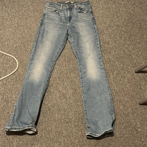 Blå jeans från Levi's 725 High Rise Bootcut - Snygga blå jeans från Levi's med klassisk design. De har en straight passform och är tillverkade i jeansmaterial. Perfekta för en avslappnad stil.