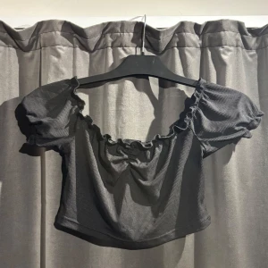 Svart ribbad croppad topp från Shein - Säljer en svart ribbad croppad topp från Shein med korta puffärmar och en söt knytdetalj framtill. Skriv gärna om eventuella frågor.🩷