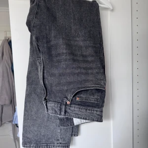 Grå jeans från H&M - Säljer ett par grå jeans från H&M i regular fit. De har en klassisk design med fem fickor och knappgylf. Perfekta för en avslappnad stil.