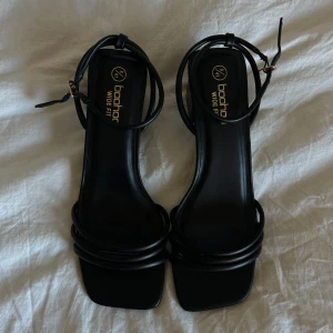 Svarta klackar från Boohoo - Snygga svarta klackar från Boohoo med bred passform och klack. De har en stilren design med smala remmar och en justerbar ankelrem. Orginal priset är 486kr, men jag vill gärna bli av med dom så fort som möjligt så säker för mycket billigare. Dom är endast testade men inte använda. Passar som 40 också skulle jag säga! 🫶🏼