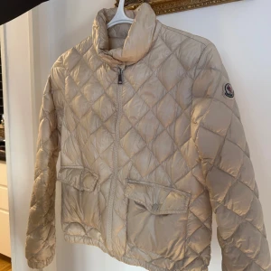 Moncler jacka - Jättefin champagne quiltad jacka från moncler! Köptes förra hösten, storlek 14 men passar mig som brukar ha xs :) Kan mötas upp i stockholm eller nacka💕