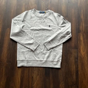 Grå tröja från Polo Ralph Lauren - Säljer en helt ny grå tröja från Polo Ralph Lauren. Rund hals, broderad logga och långa ärmar. Perfekt för en avslappnad look. Priset kan diskuteras.