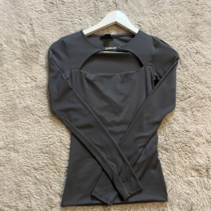 Grå fest topp från Amisu - Snygg grå långärmad topp från Amisu med en unik cut-out detalj vid halsen. Toppen är aldrig använd och är i topp skick!