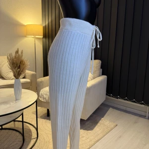 Vita ribbade byxor med knytband - Snygga vita ribbade byxor med hög midja och knytband i midjan. Perfekta för en avslappnad stil med en bekväm passform. Passar perfekt som oversize modell (s/m/l storlek). Jag rekommenderar dem varmt.🌸👌