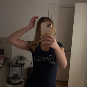 Mörkblå t-shirt med glittrig text - Snygg mörkblå t-shirt med glittrig text. T-shirten har korta ärmar och en rund halsringning.🥰🥰