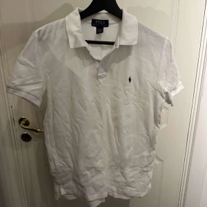 Vit kortärmad pikétröja från Polo Ralph Lauren - Säljer en vit pikétröja från Polo Ralph Lauren. Använd en gång. Storlek L=(Barn 14-16) som en XS